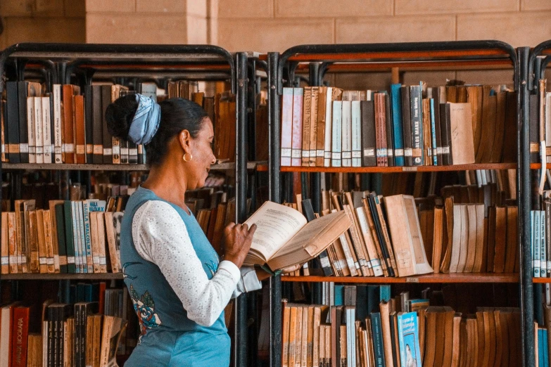 a person stands near a book shelf in front of a row of books