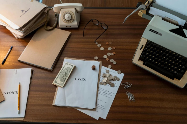 an old typewriter and two sheets of paper next to the typewriter