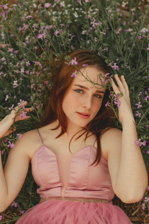 woman with red hair, in a pink dress surrounded by lavender flowers