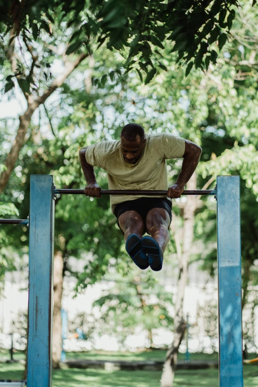 a man hanging upside down with his legs crossed above the bar