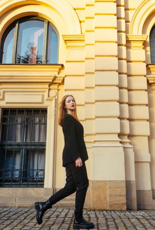 a young woman walking on the street wearing black