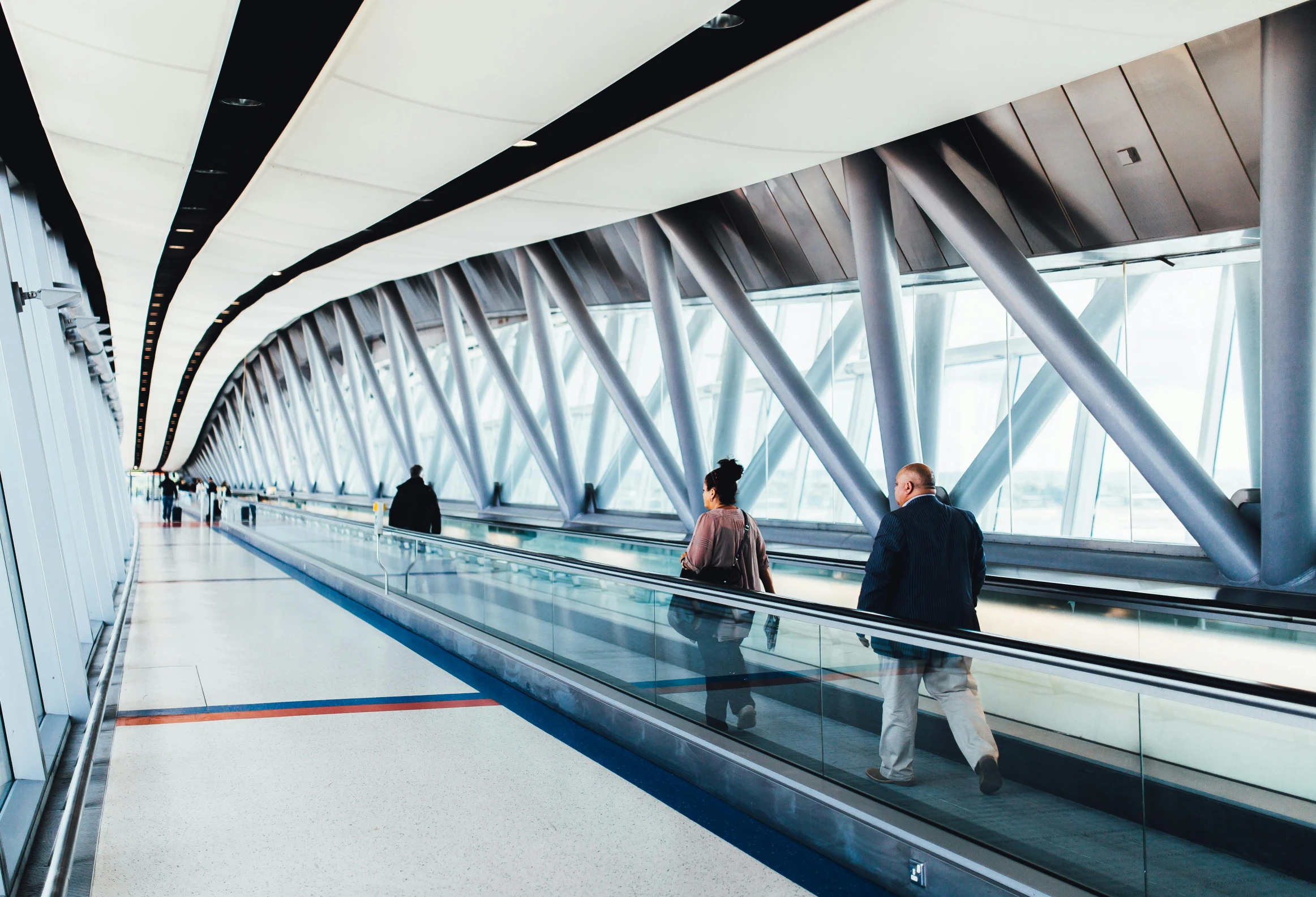 several people are riding an escalator in the airport