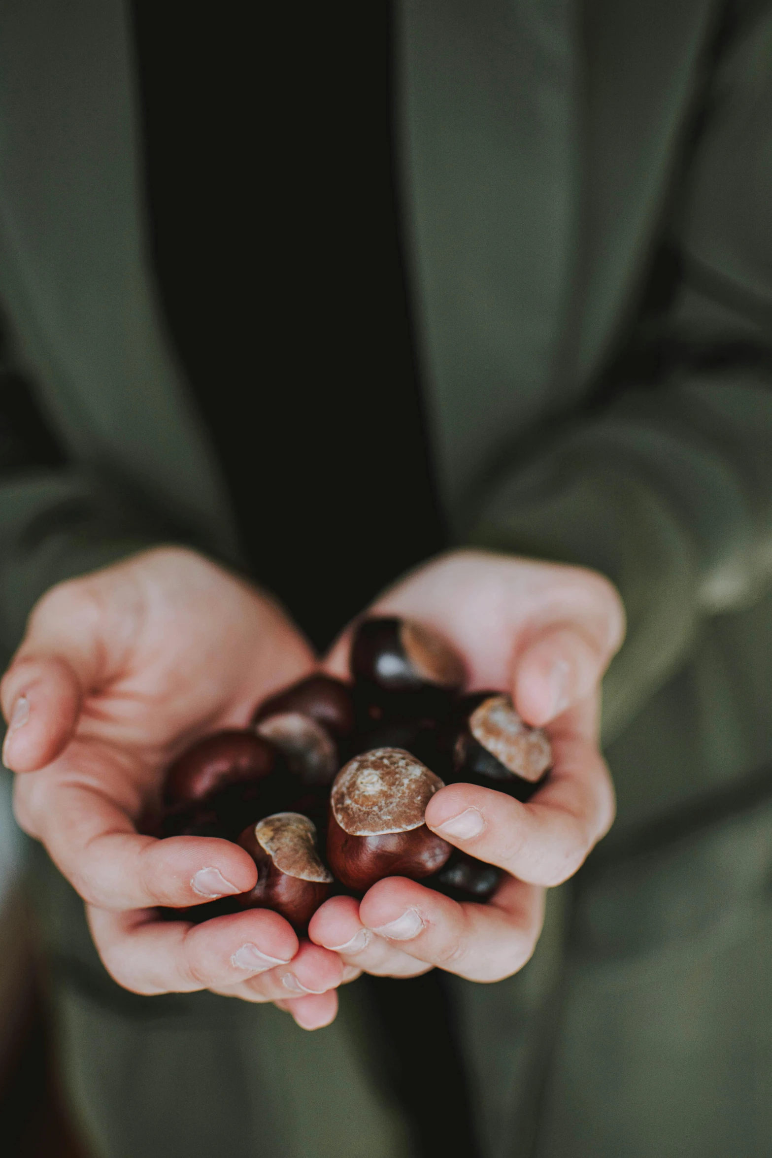 a man wearing a suit holding two hands full of nuts