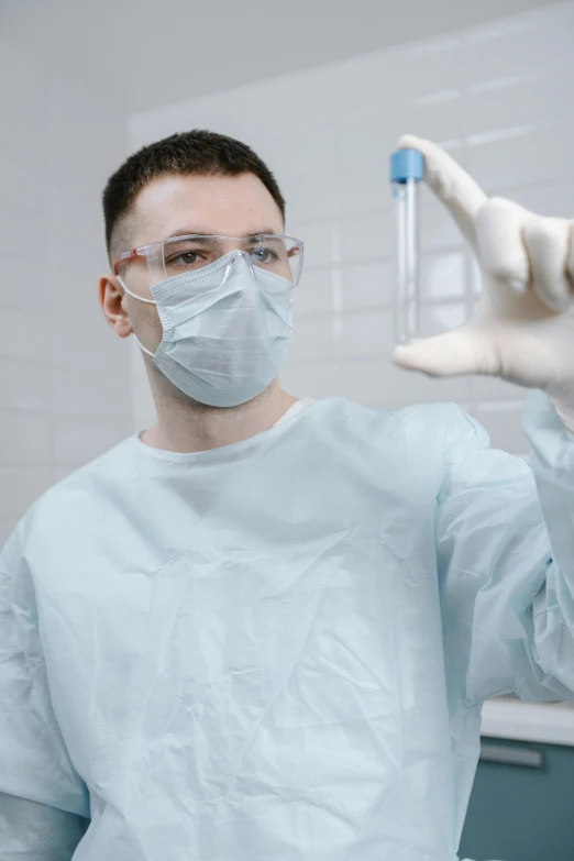 an surgeon wearing goggles holds up the arm of an outstretched hand