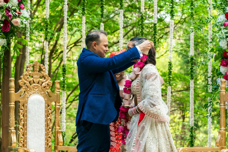 a couple is posing for pictures in front of flowers and decor