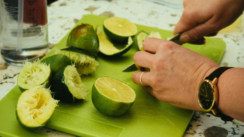 someone  up fruits with scissors on a green board