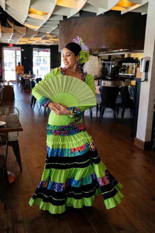 the woman is dressed in a colorful dress and holding a fan