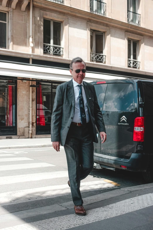 a man in a suit and tie walking down the street