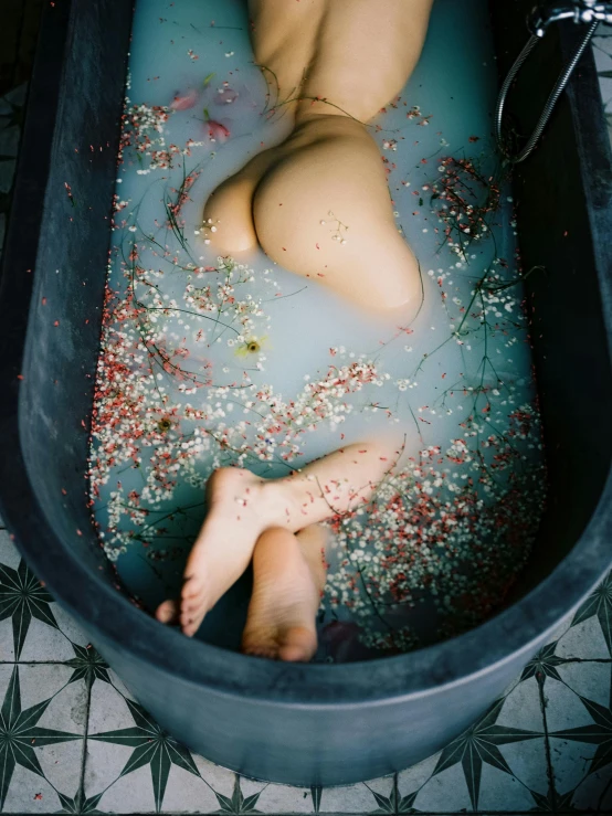 the  woman is laying in a tub