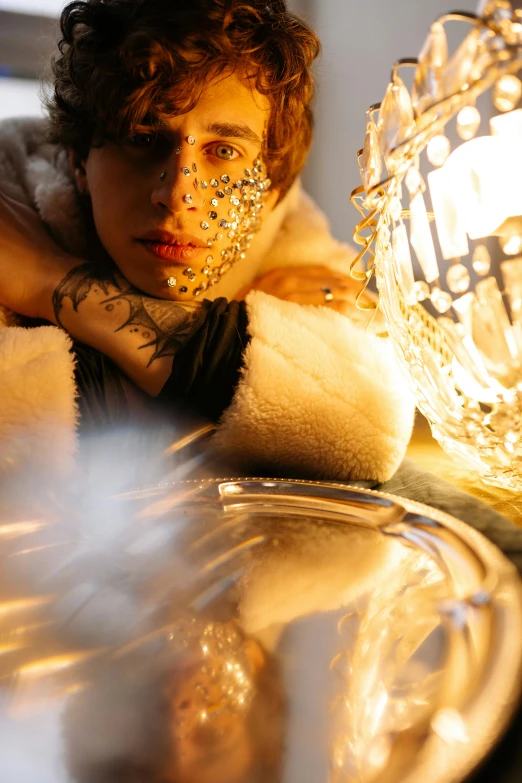 a person with some face tattoos near a glass ball