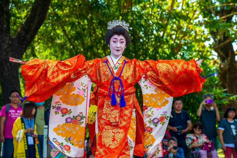 an asian man in a brightly colored outfit walking