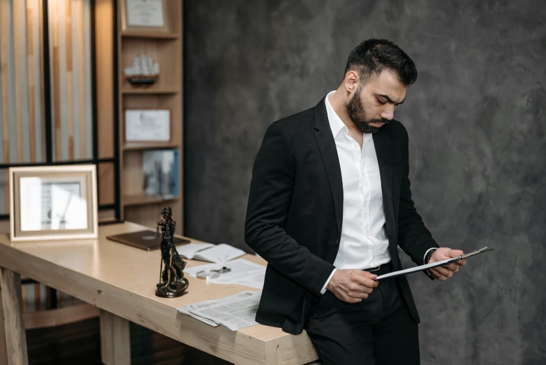 a man looking at his tablet pc while standing in a desk