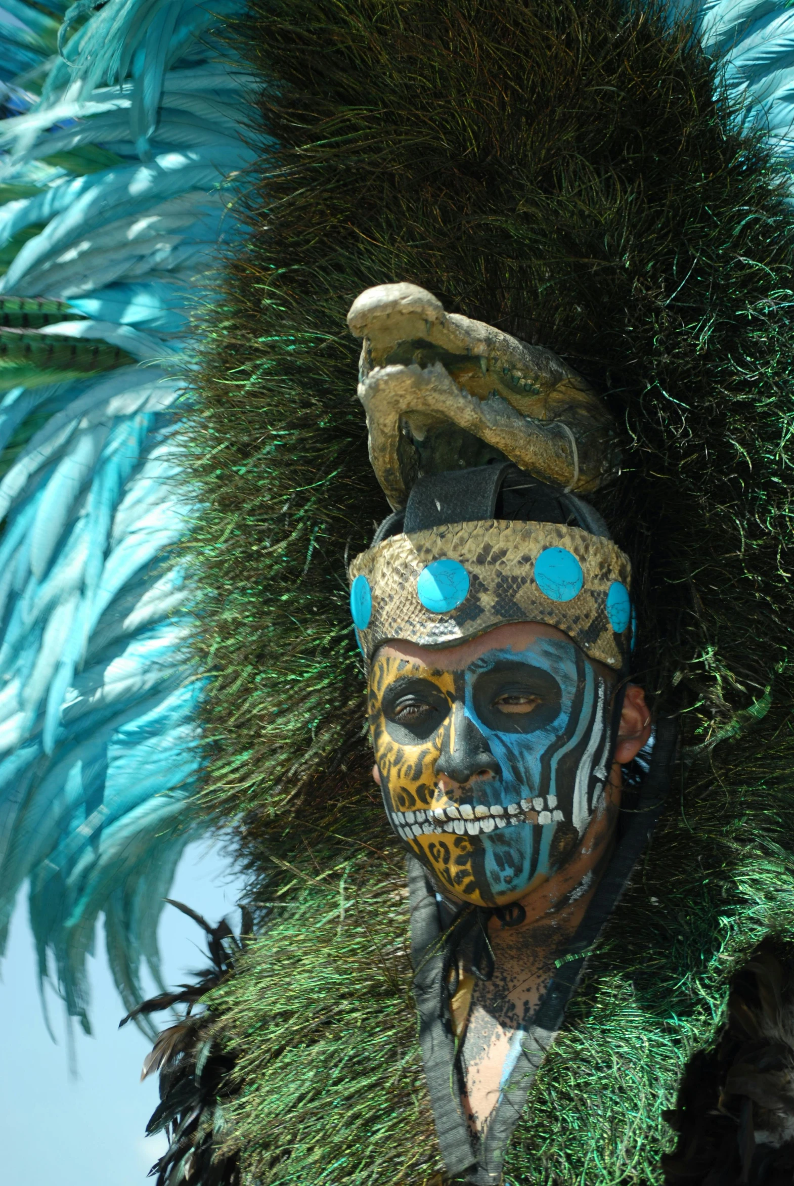 an elaborately decorated mask displayed on top of a tree