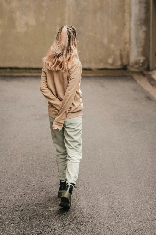 a little girl wearing a sweater standing in the street