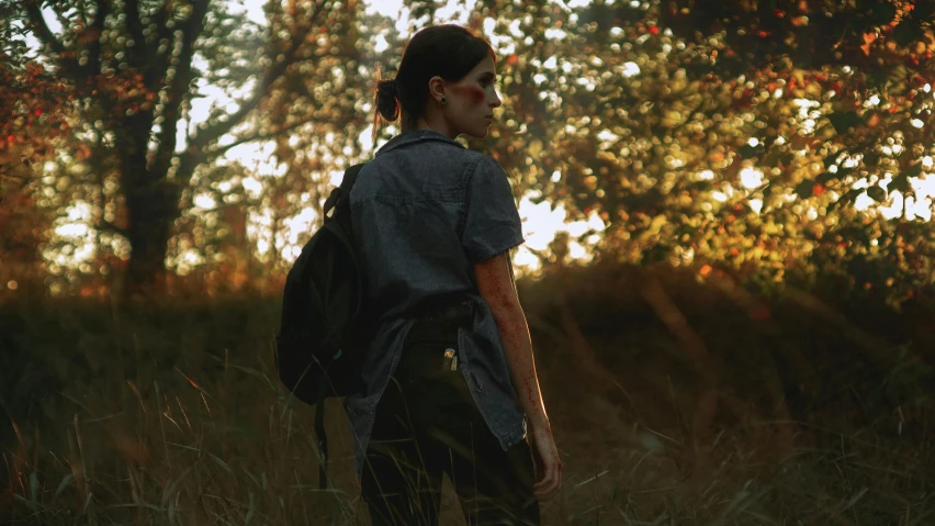 there is a male student standing alone in the woods