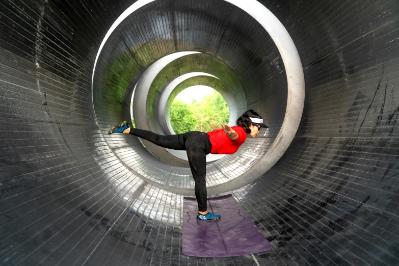 a woman practicing yoga inside a tunnel