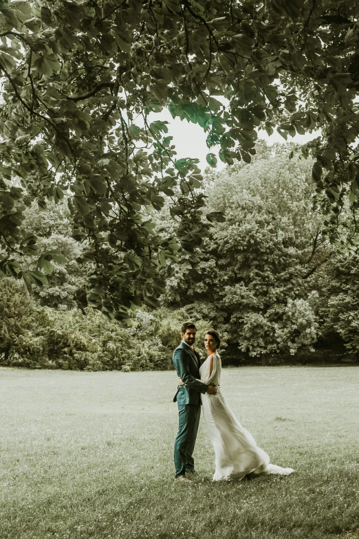 a couple of people in some grass by some trees