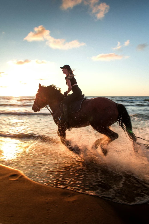 there is a woman that is riding a horse by the water