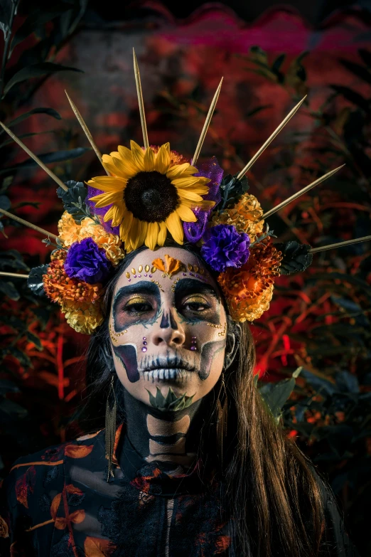 a woman with flowers on her head and makeup painted orange, yellow and purple