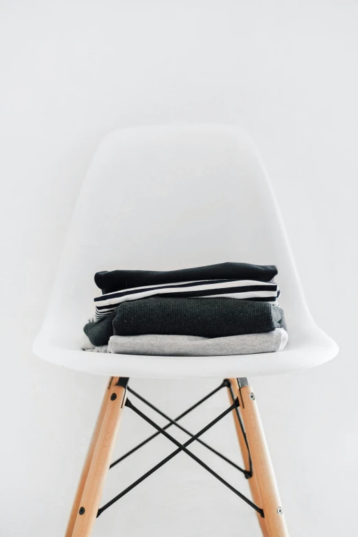 a stack of black and white folded clothing sitting on top of a wooden leg