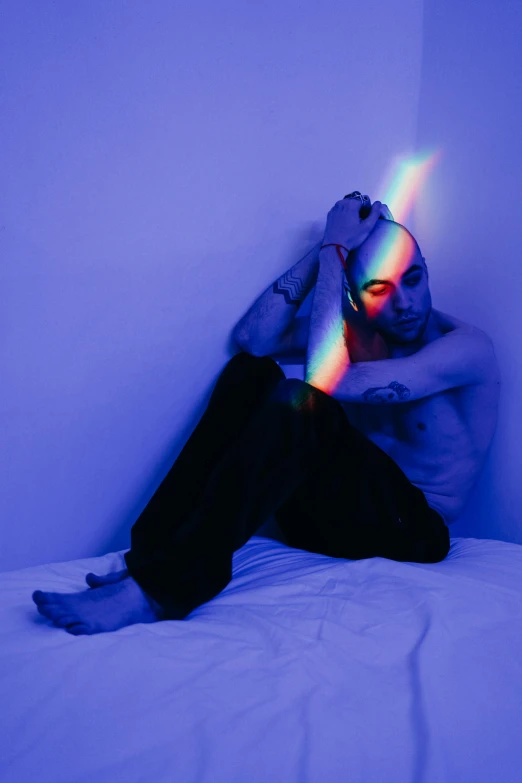 a man with headphones sitting in bed in the dark