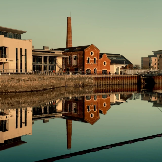 brick building in water front area and city buildings nearby