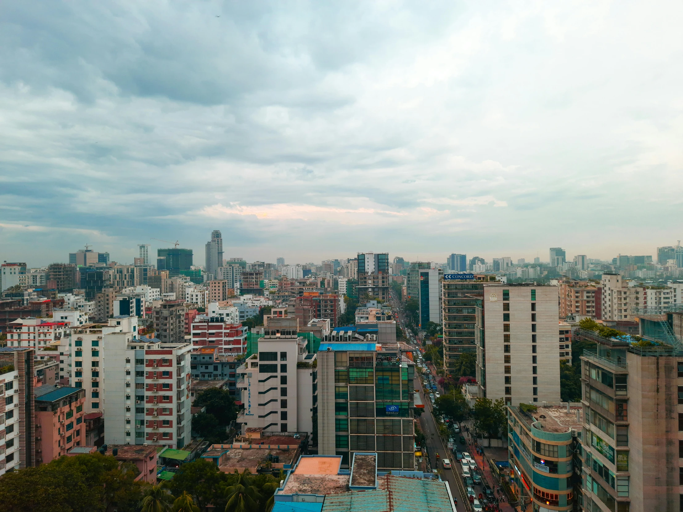 a bunch of tall buildings with a cloudy sky in the background