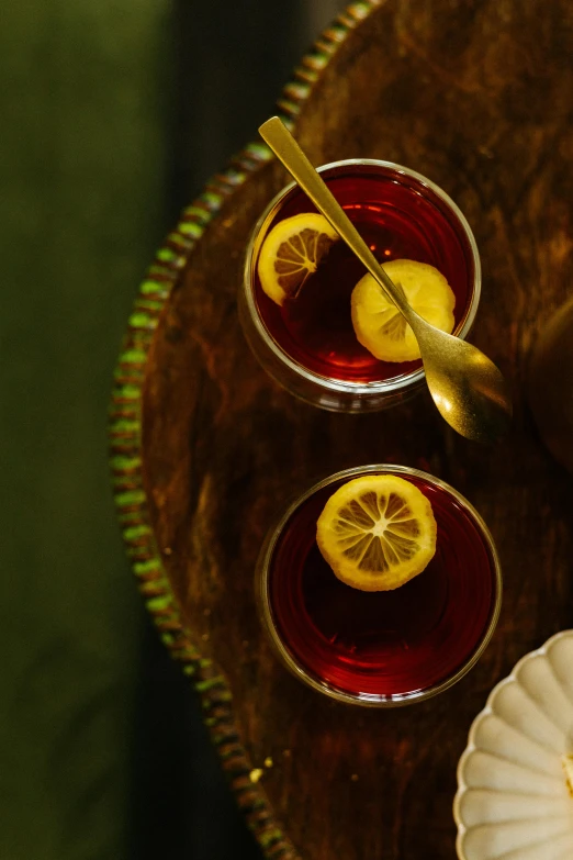 two glasses of juice sitting on a table with silverware