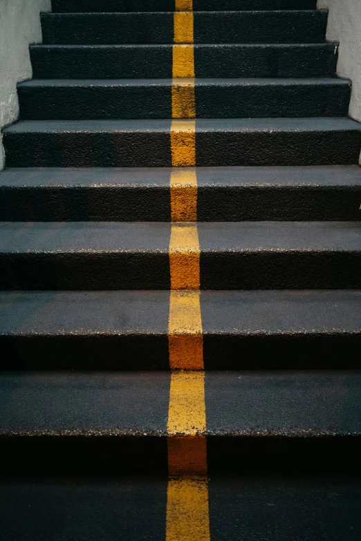 the steps with yellow stripes are lined with concrete