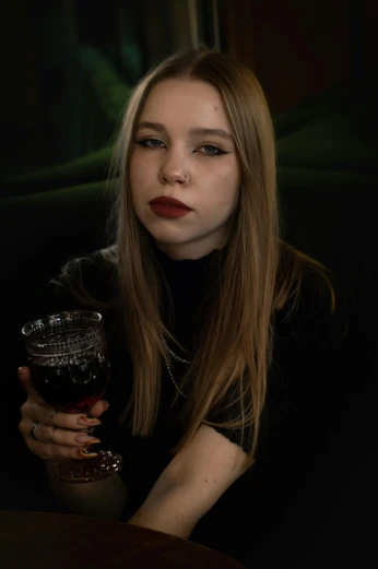 a woman is holding a glass of wine