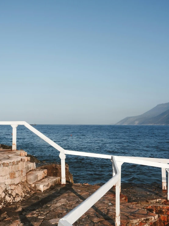 a stone walkway next to a body of water