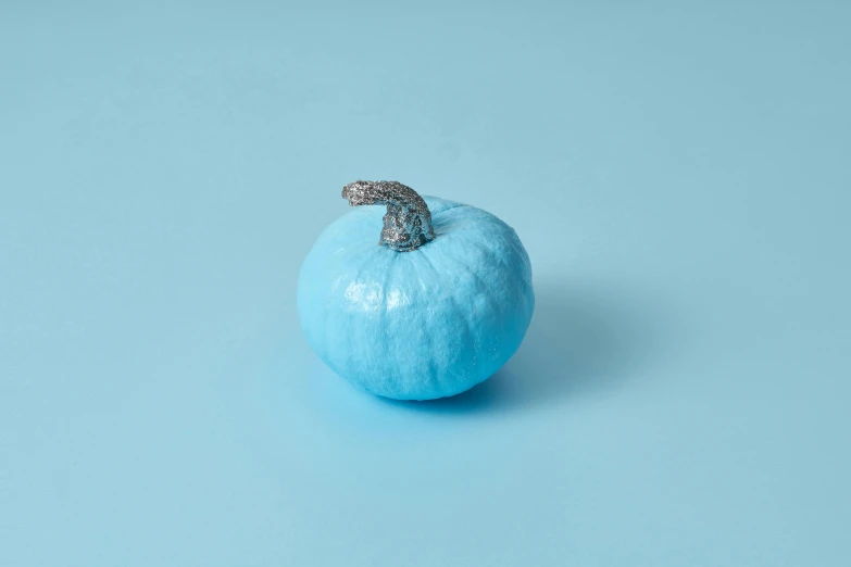 a blue fruit sitting on a blue background