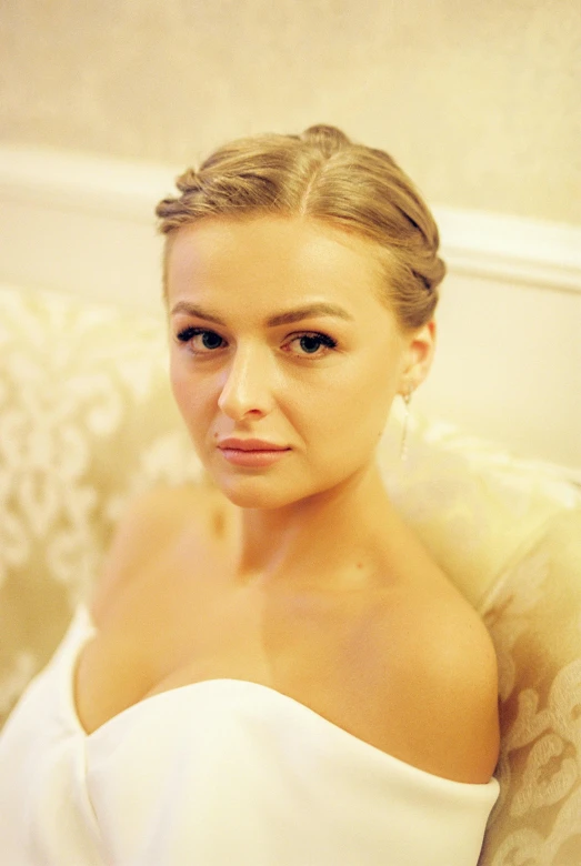 a young woman is sitting on a couch posing for a picture