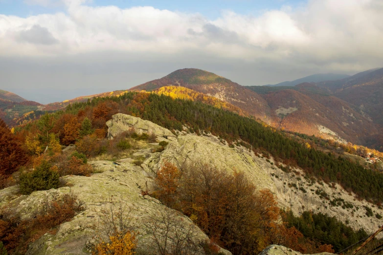 a scenic scene from the top of a mountain with trees and mountains in the distance