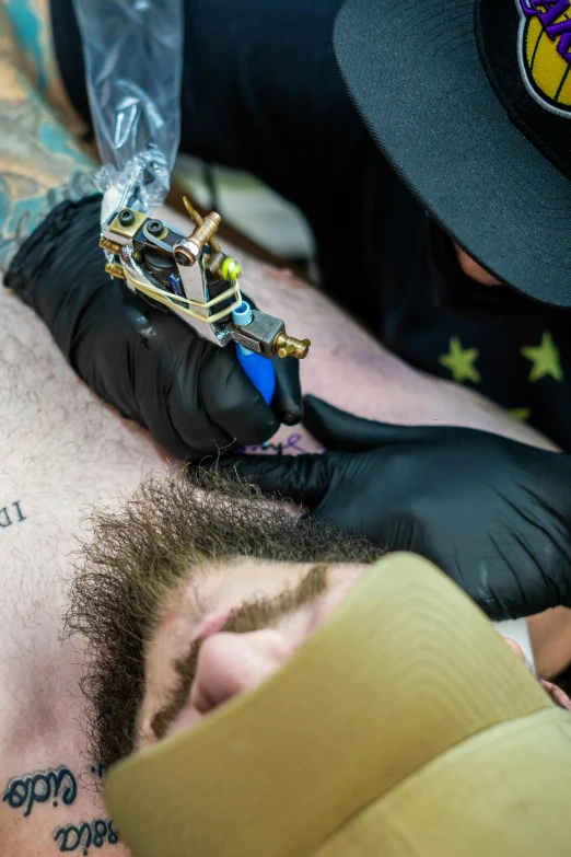 a tattoo artist doing an art project on a man's head