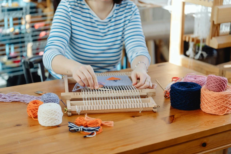 a woman that is looking at the knitting machine