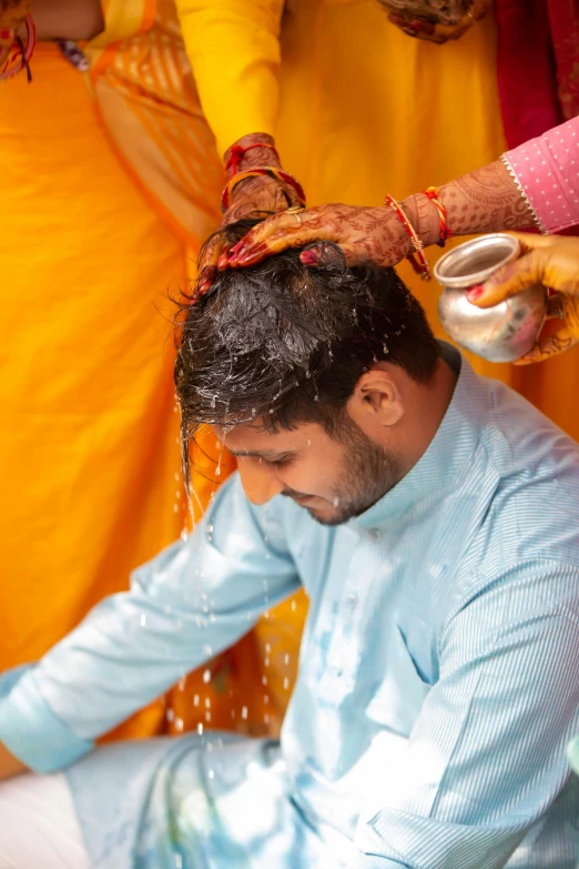 a man in a blue dress is getting his hair dried