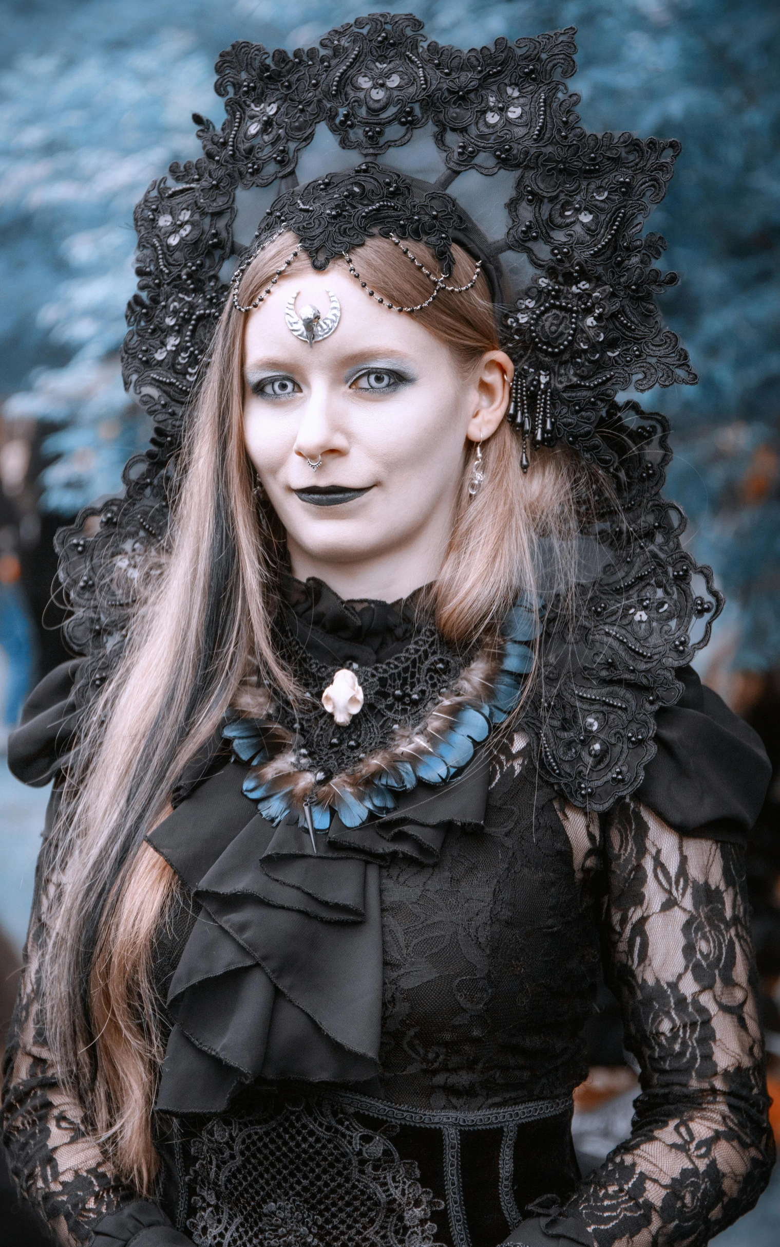 a woman with blue eyes wearing a veil and black outfit