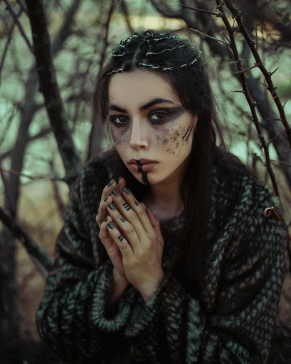 girl with dark makeup and black make up in the woods