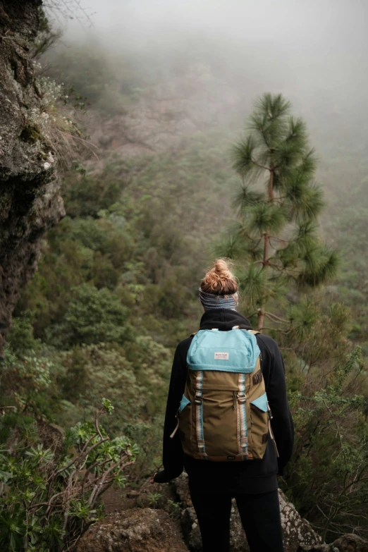 a woman with her back turned on looking down a steep hill