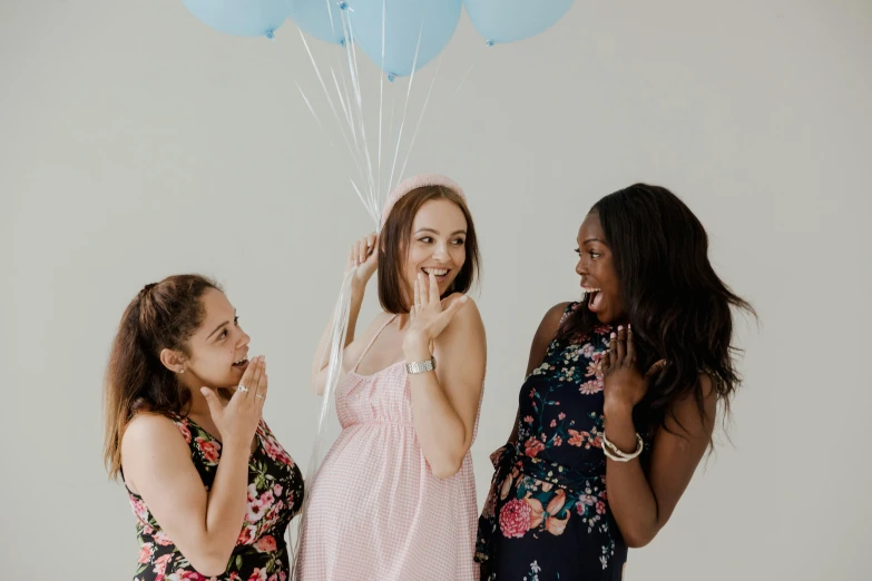 three girls dressed in dresses with balloons