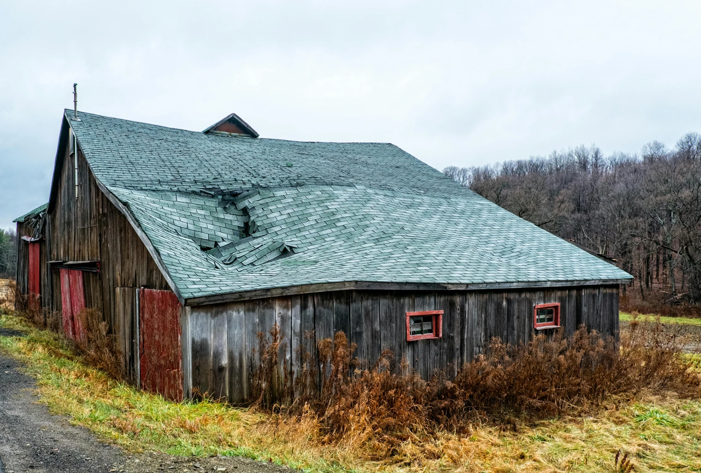 an old barn on a country road in a rural area