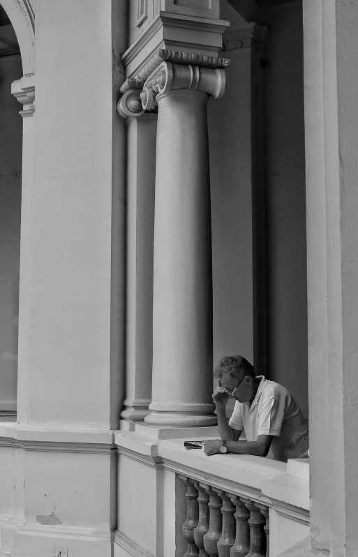 a man is sitting on the ledge of an old building