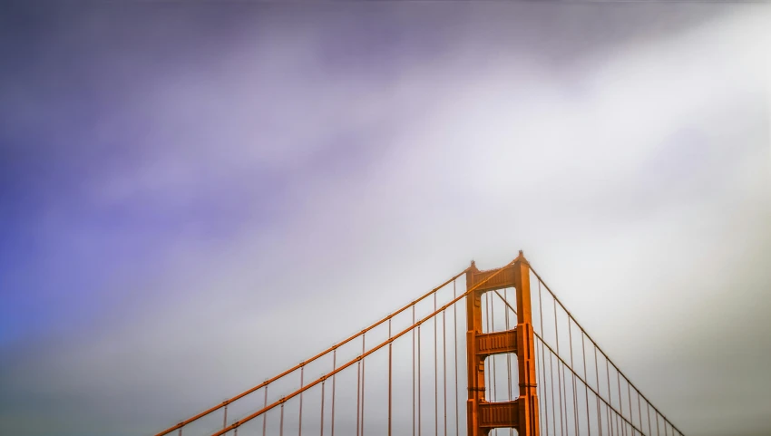 golden gate bridge is in the fog on a cloudy day