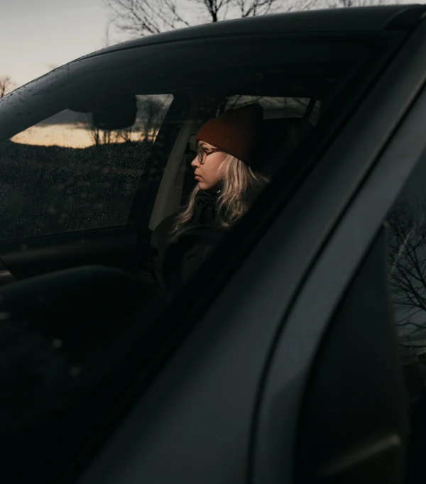 a person sitting in a car on the street