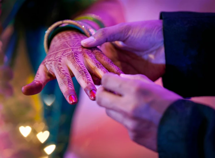 a close up of two people holding hands