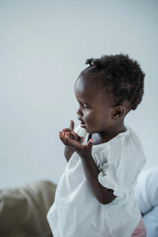 the child is dressed in a white outfit