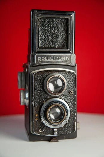 an old camera is on display with red background