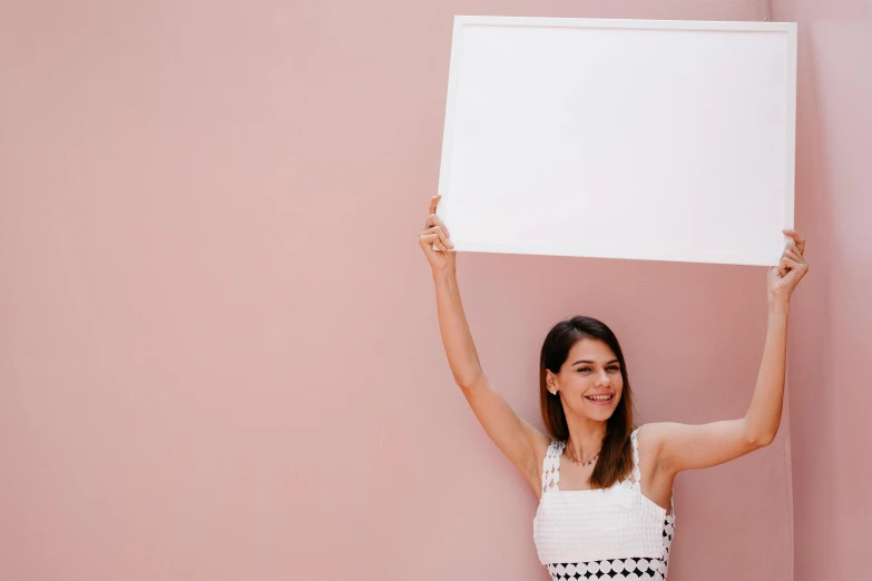 the woman holding up an empty white piece of paper