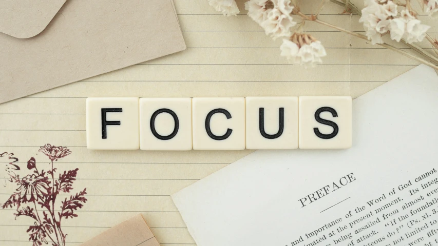 letter block type words written in small letters with the word focus on paper and a pair of glasses next to it